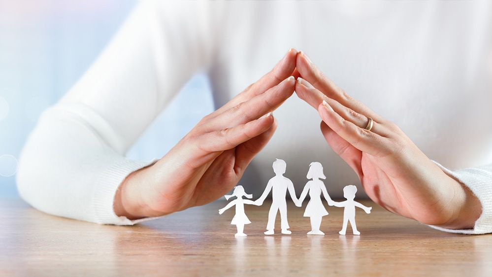 Soziale Sicherheit als Symbol mit Händen über einer Familie